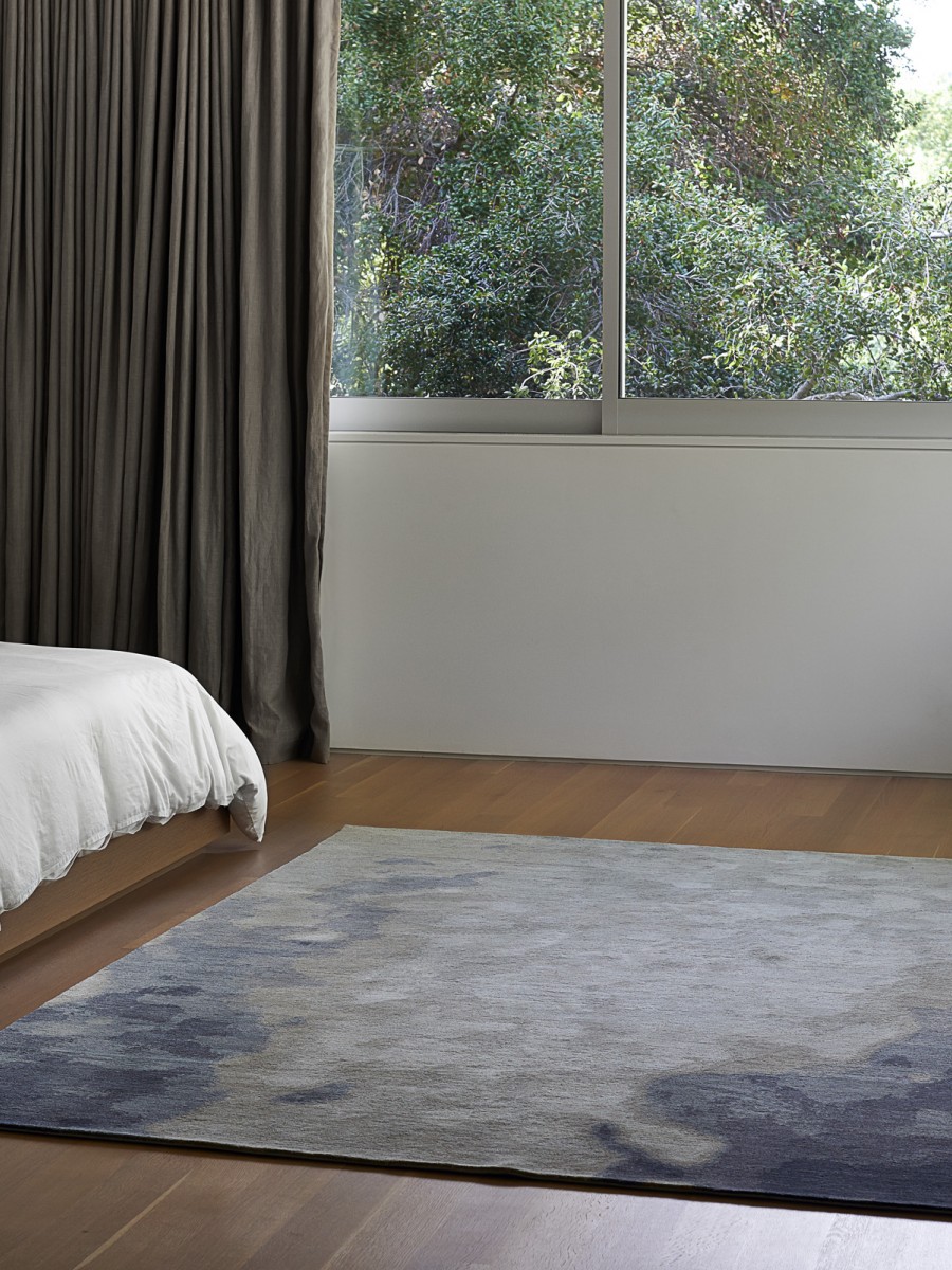 Ice Shelf rug by Erik Lindstrom displayed in a beautiful bedroom with large windows 