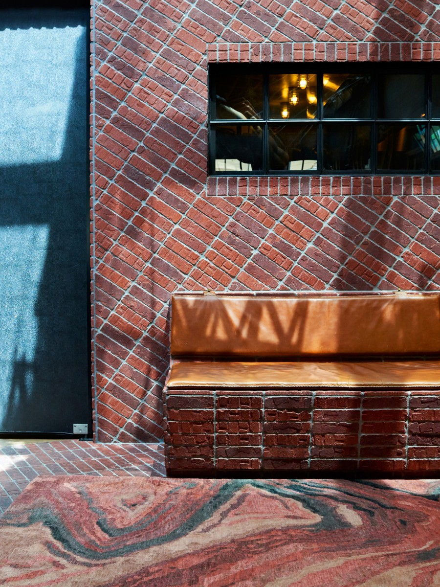 Laguna rug in a lobby with brick walls and orange bench 