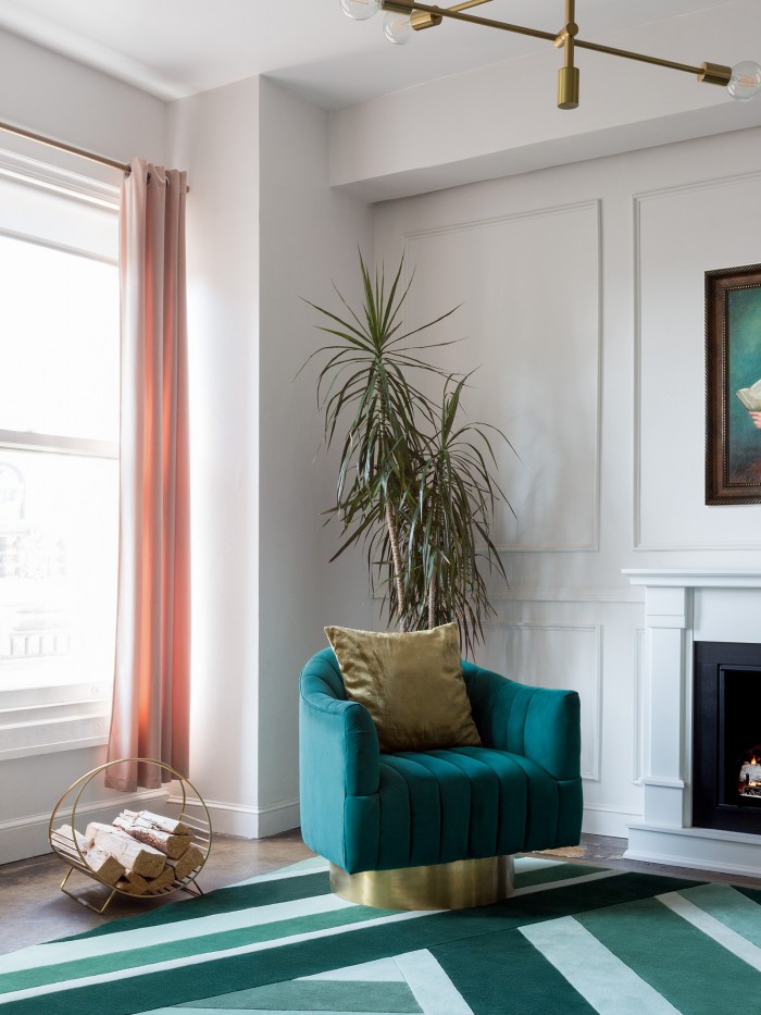 Mint colored Geometric rug paired with green chair in a living space 