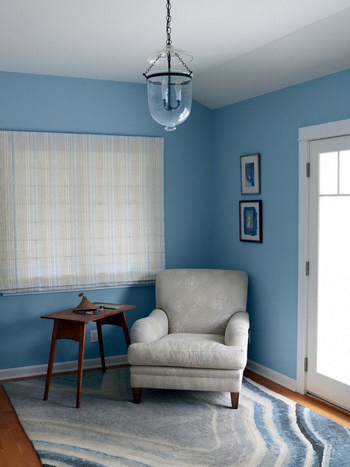 Agua Nueva Rug by Erik Lindstrom displayed in bedroom with a white chair 